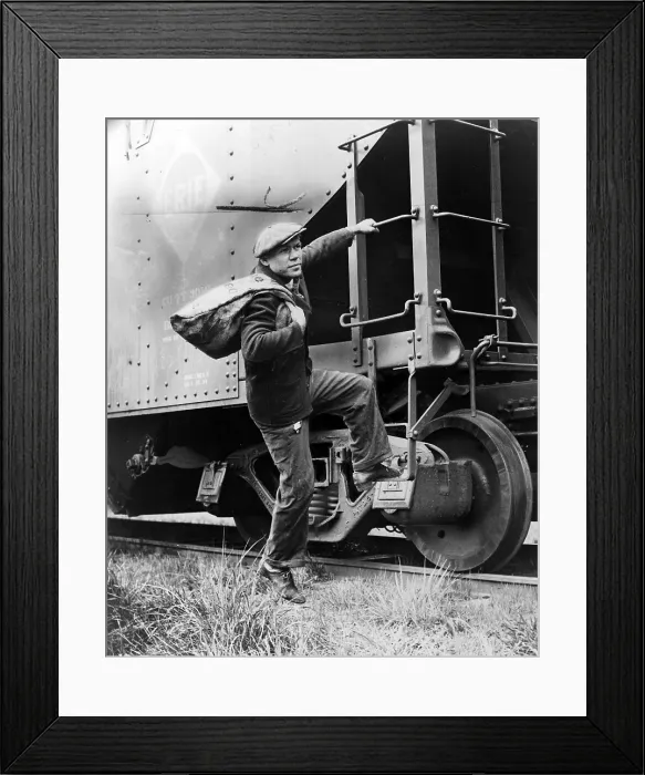Framed Print : Hobo, Lou Ambers with a large bag over shis shoulder, mounting the ladder of a train car, 1935