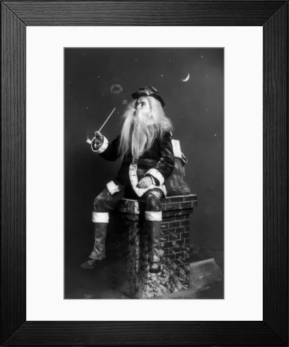 Framed Print : Christmas, caught in the act, Santa Claus seated on model of chimney smoking long pipe and blowing circles of smoke, photograph, 1900 Framed Print : Christmas, caught in the act, Santa Claus seated on model of chimney smoking long pipe and blowing circles of smoke, photograph, 1900