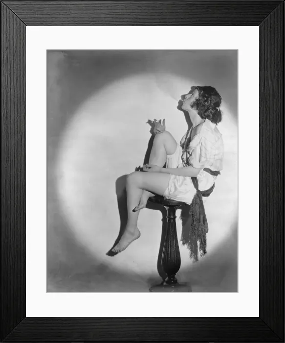 Framed Print : Full length portrait of young woman smoking a cigarette, seated on pedestal, in profile, photograph, 1922 Framed Print : Full length portrait of young woman smoking a cigarette, seated on pedestal, in profile, photograph, 1922