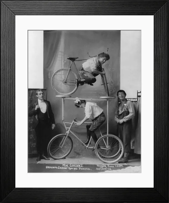 Framed Print : Circus and vaudeville acts, a woman between bars of bicycle on platform over tricycle, caption: Mae Gordon's original insane moving pedestal, circa December 9, 1907 Framed Print : Circus and vaudeville acts, a woman between bars of bicycle on platform over tricycle, caption: Mae Gordon's original insane moving pedestal, circa December 9, 1907