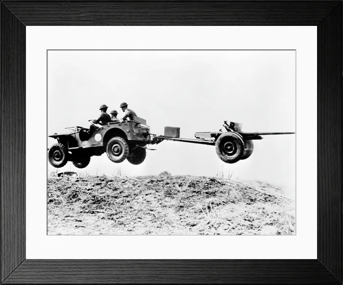 Framed Print : The new jeep in mid-air as it pulls a small artillery piece ca. 1941