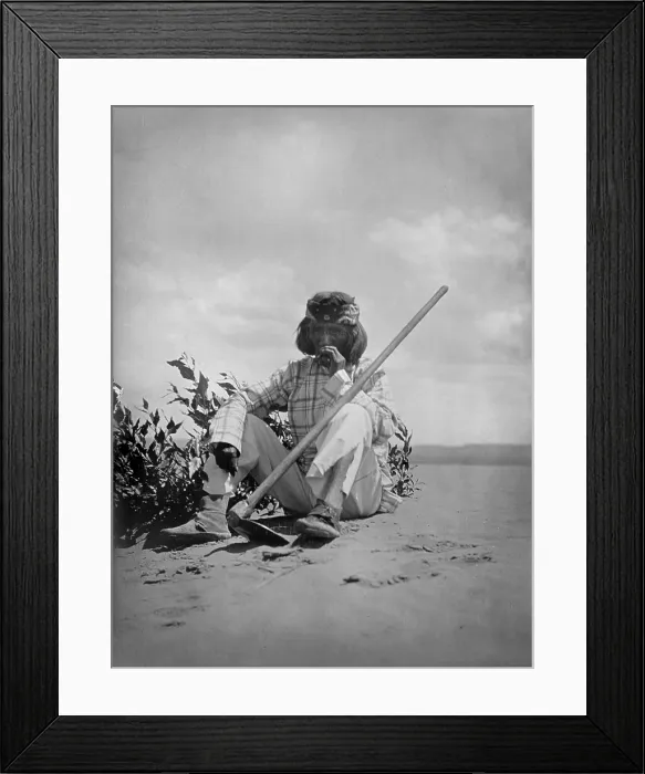 Framed Print : Hopi man sitting on ground smoking, with hoe propped on his left knee, original title: A quiet smoke Hopi, photograph by Edward S. Curtis, 1907
