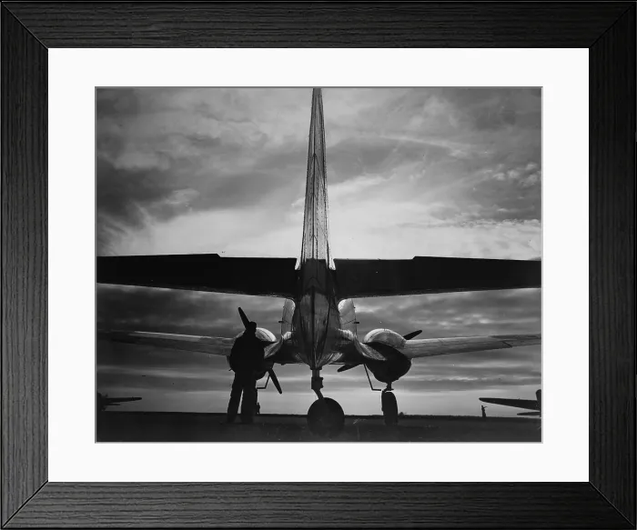Framed Print : World War II, soldier beside WWII airplane at sunrise, circa early 1940s