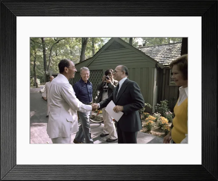 Framed Print : President Jimmy Carter watches Egyptian president Anwar Sadat (L) shake hands with Israeli prime minister Menachem Begin (R). First Lady Rosalynn Carter is at far right