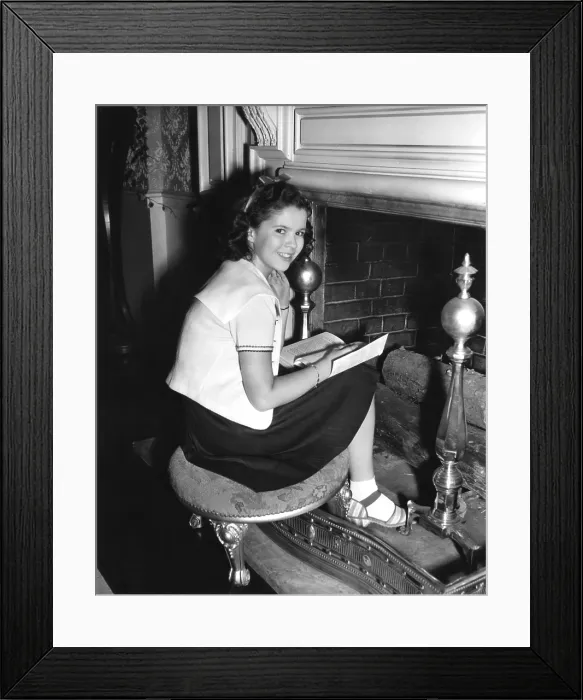Framed Print : KATHLEEN, Shirley Temple, catching up on her reading between takes, 1941