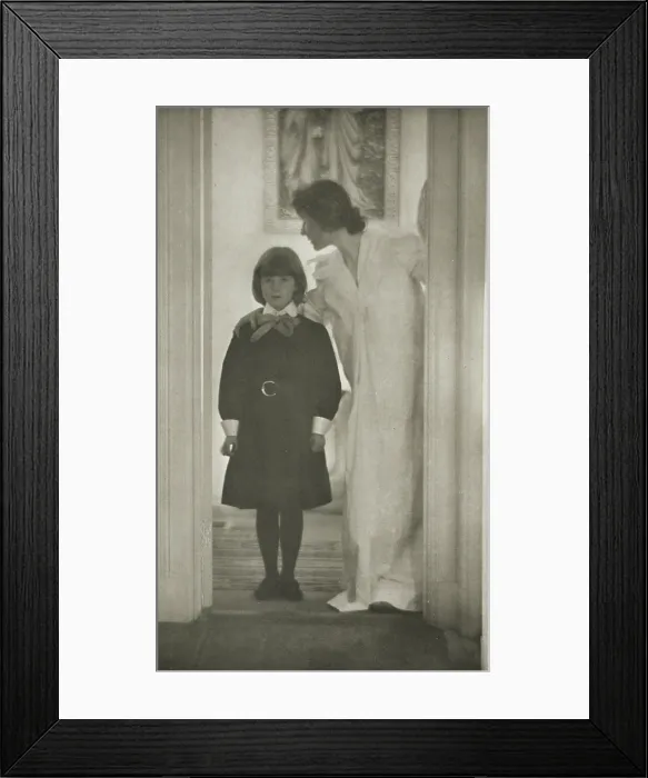 Framed Print : Mother and daughter standing in a doorway, with a picture of the Annunciation on the wall behind them