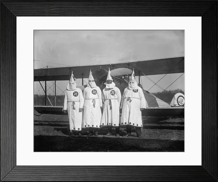 Framed Print : The Ku Klux Klan, one with flight goggles, in front of airplane, swastika adorns plane rear, March 18, 1922