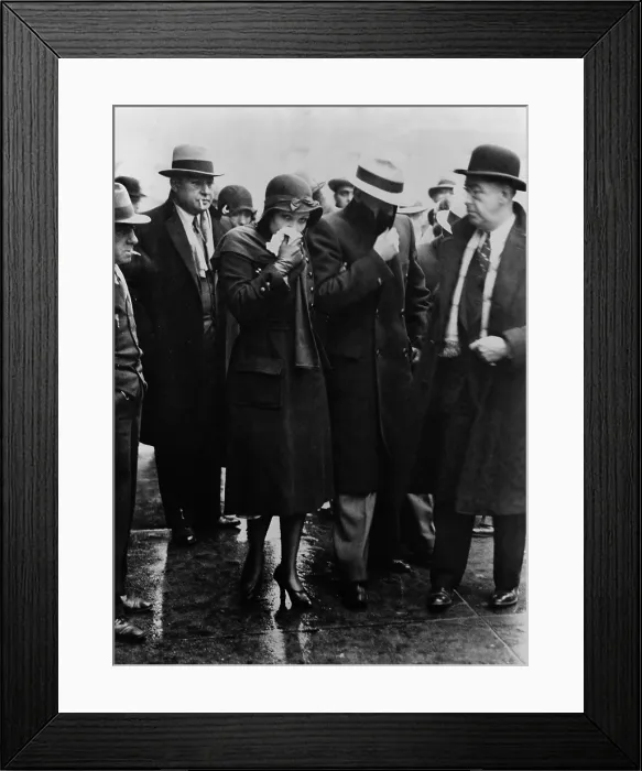 Framed Print : Mr. and Mrs. Vincent Coll, hiding their faces from photographers as they leave court after Coll was acquitted of the murder of five year old, Michael Vengalli. December 1931