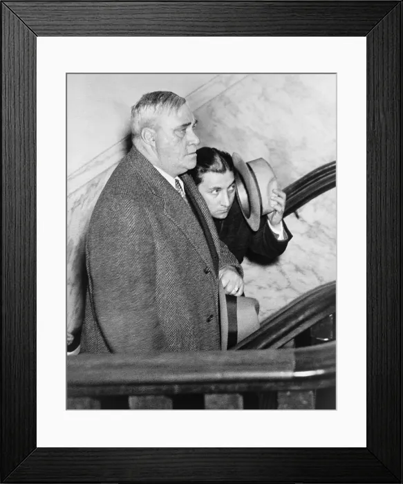 Framed Print : Irving Bitz (1903-1980), attempting to shield his face from photographers while in the custody of a police detective on January 30, 1933