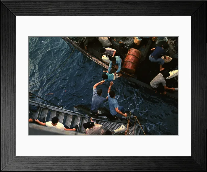 Framed Print : Vietnam War, South China Sea, crewmen of the amphibious cargo ship USS Durham (LKA-114) take Vietnamese refugees aboard a small craft Framed Print : Vietnam War, South China Sea, crewmen of the amphibious cargo ship USS Durham (LKA-114) take Vietnamese refugees aboard a small craft