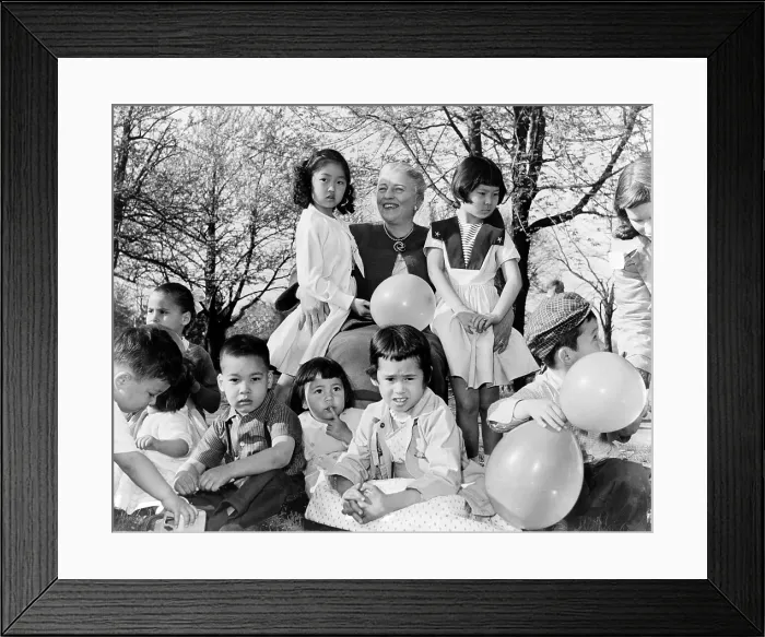 Framed Print : Pearl S. Buck (1892-1973), sits outdoors with group of Chinese-American children placed with families through her Welcome House adoption agency