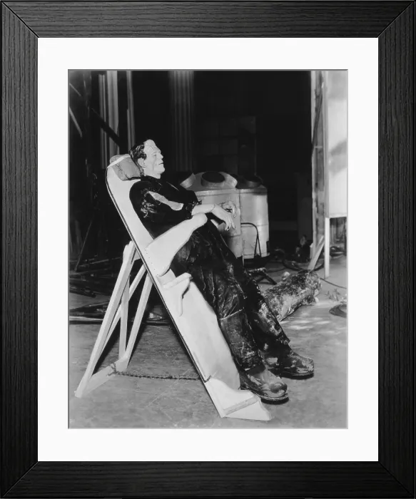 Framed Print : FRANKENSTEIN, Boris Karloff on a reclining board between scenes on set, 1931