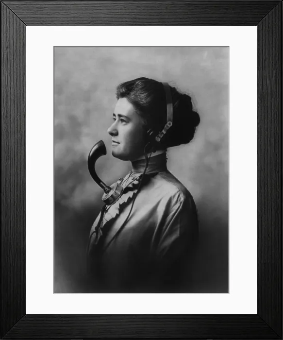 Framed Print : A female telephone operator wearing earphones and a mouth piece. Ca. 1911