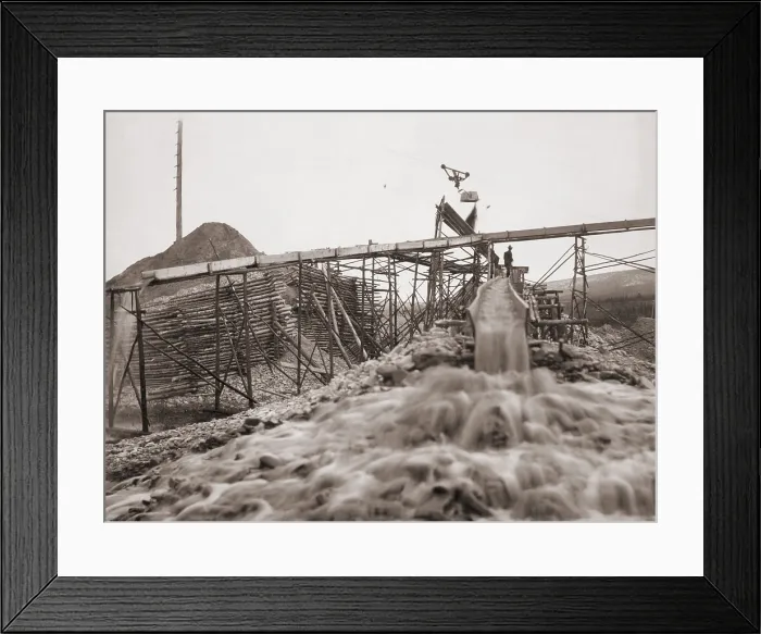 Framed Print : Washing gold in a sluice box placed in the stream to channel water flow