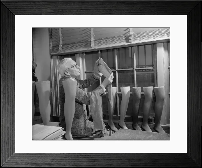 Framed Print : Agriculture Department fabric technician examines the cotton stockings that would replace those made by Japanese silk