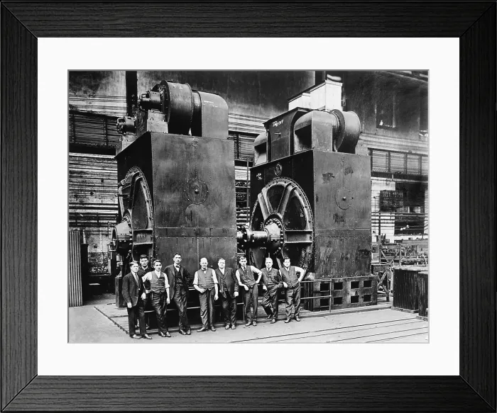 Framed Print : Nine men in suits are dwarfed by two massive dynamos, (electric generators) in a factory. Ca. 1920 Framed Print : Nine men in suits are dwarfed by two massive dynamos, (electric generators) in a factory. Ca. 1920