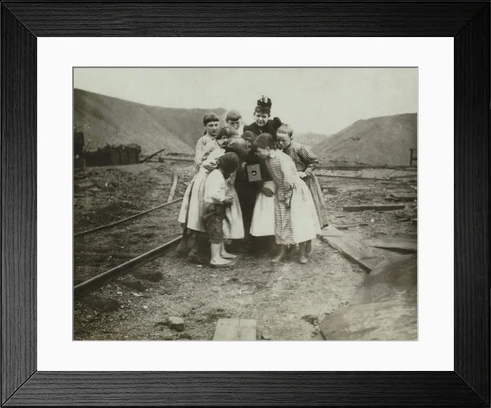 Framed Print : Photographer Frances Benjamin Johnston (back center), with group of children looking at her camera, titled: A Kodak creates a sensation, 1890-1910