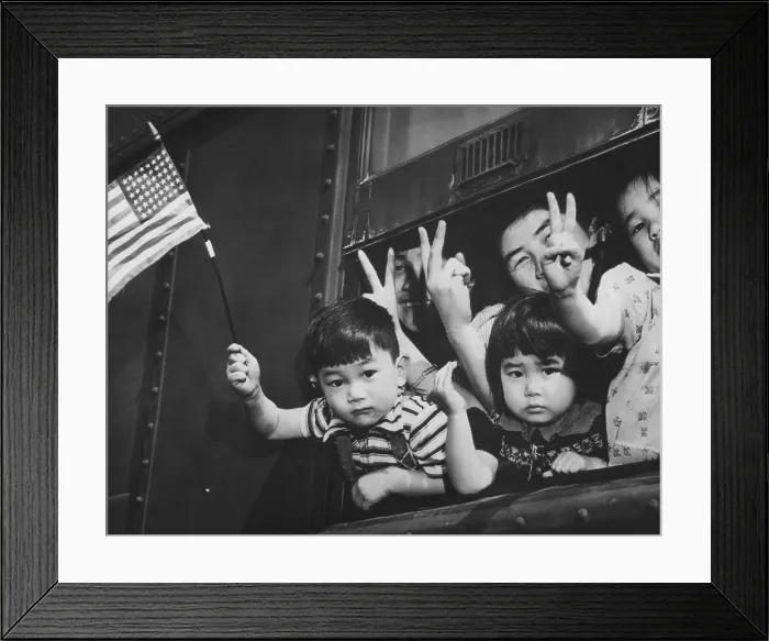 Framed Print : Japanese-American children waving from a train window as it leaves Seattle to take them to an internment camp for the duration of World War II. March 1942