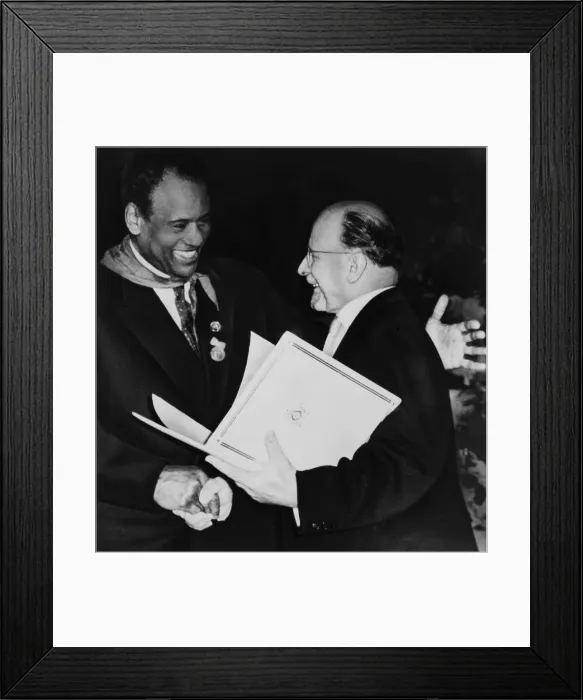 Framed Print : Paul Robeson (1898-1976), dances a freedom dance with an amateur African cultural group during his visit communist East Germany in 1960 Framed Print : Paul Robeson (1898-1976), dances a freedom dance with an amateur African cultural group during his visit communist East Germany in 1960