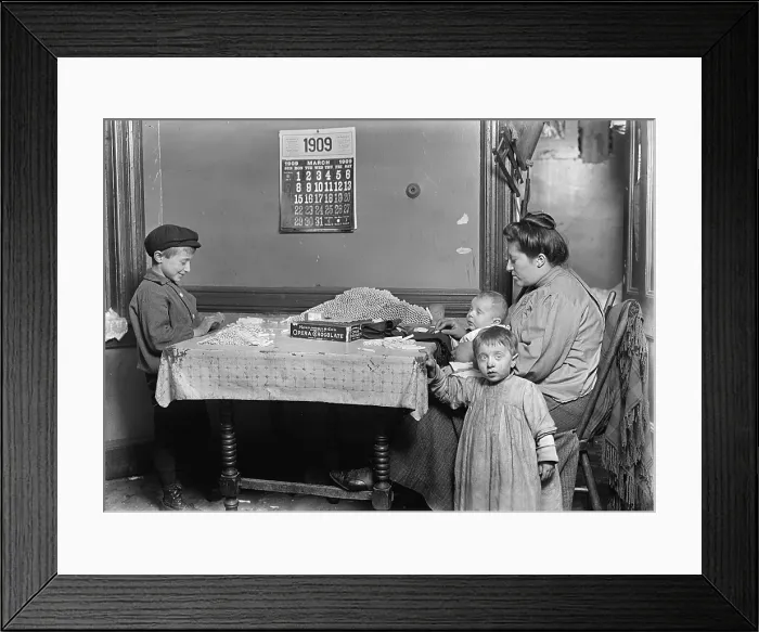 Framed Print : Child labor, Widow & boy rolling papers for cigarettes in a dirty tenement, New York, photograph by Lewis Wickes Hine, March, 1909