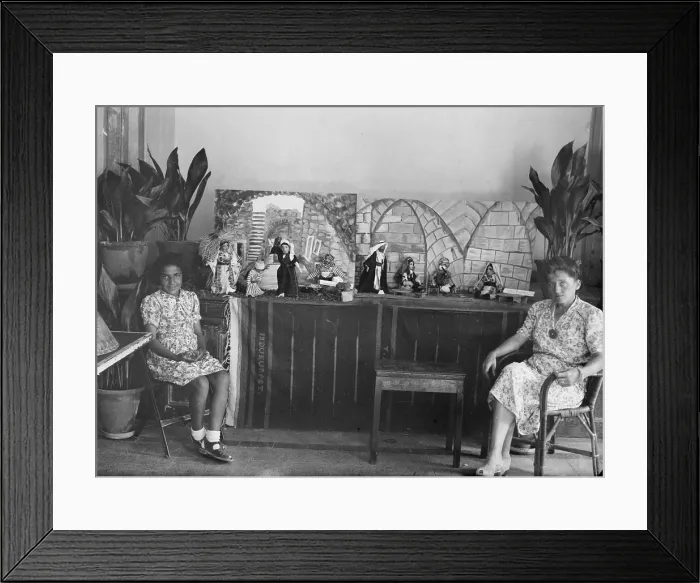 Framed Print : Woman and girl seated in front of dolls which are wearing traditional Arab dress, one group of dolls has label Dolls Ramallah, photograph, circa 1920-1946 Framed Print : Woman and girl seated in front of dolls which are wearing traditional Arab dress, one group of dolls has label Dolls Ramallah, photograph, circa 1920-1946