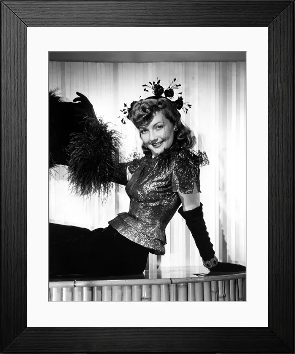 Framed Print : THE NIGHT BEFORE THE DIVORCE, Lynn Bari, in a cocktail outfit of a silver-lame blouse over a black velvet skirt, with suede gloves and an ostrich-feather muff, 1942