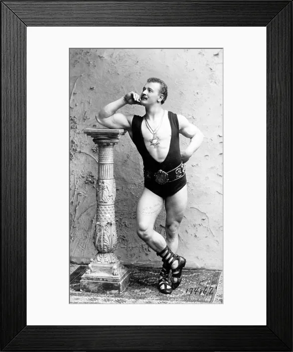Framed Print : Eugen Sandow (1867-1925) strong man and body builder, wearing wrestling leotard and leaning on column. Photo c. 1894