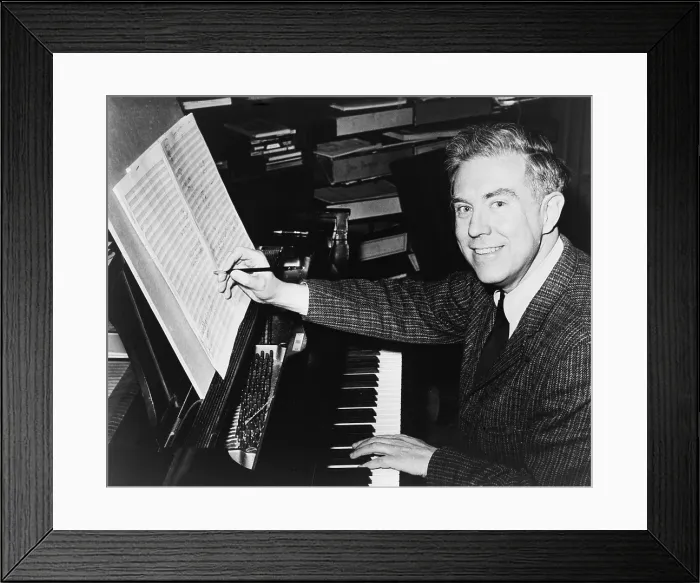 Framed Print : Elliott Carter (b. 1908), American composer seated at piano, editing sheet of music