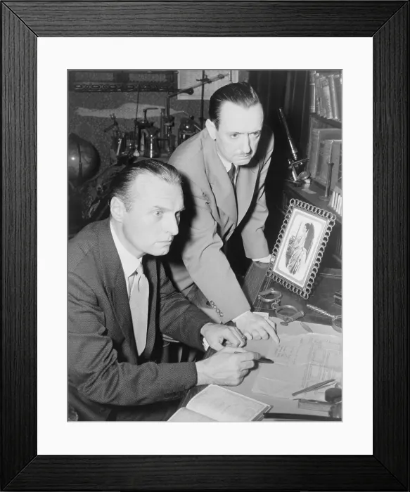 Framed Print : Adrian Conan Doyle (1910-1977), son of Arthur Conan Doyle (1868-1952), and mystery writer John Dickson Carr (1906-1977) at desk, plotting a new Sherlock Holmes story. 1952