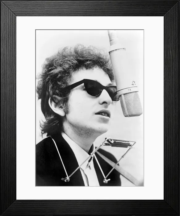 Framed Print : Bob Dylan (b. 1941) with harmonica, standing behind overhead microphone. 1967