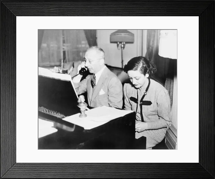 Framed Print : Jerome Kern (1885-1945), talking on the telephone while his lyricist, Dorothy Fields (1905-1974), works at the piano, 1945 Framed Print : Jerome Kern (1885-1945), talking on the telephone while his lyricist, Dorothy Fields (1905-1974), works at the piano, 1945