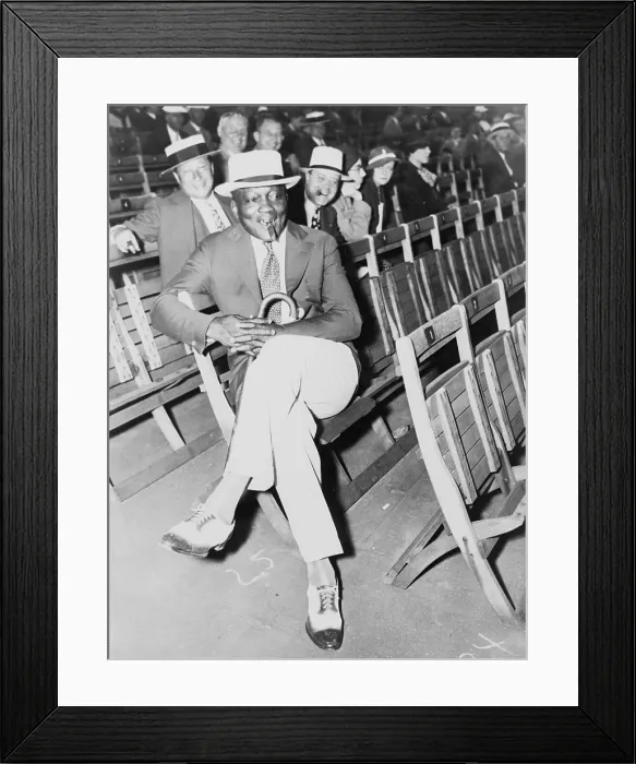 Framed Print : Jack Johnson (1878-1946) smoking a cigar and a holding cane while watching Baer-Carnera fight in Madison Square Garden in 1934