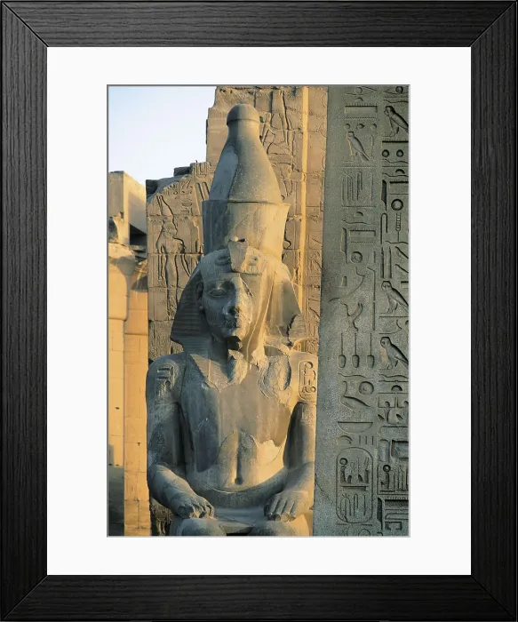Framed Print : Temple of Amon - Ra. EGYPT. Luksor. Thebes. Temple of Amon - Ra. Pylon of Ramses II (13th c. BC). Colossal statue of the Pharaoh by the obelisk. Egyptian art. New Kingdom