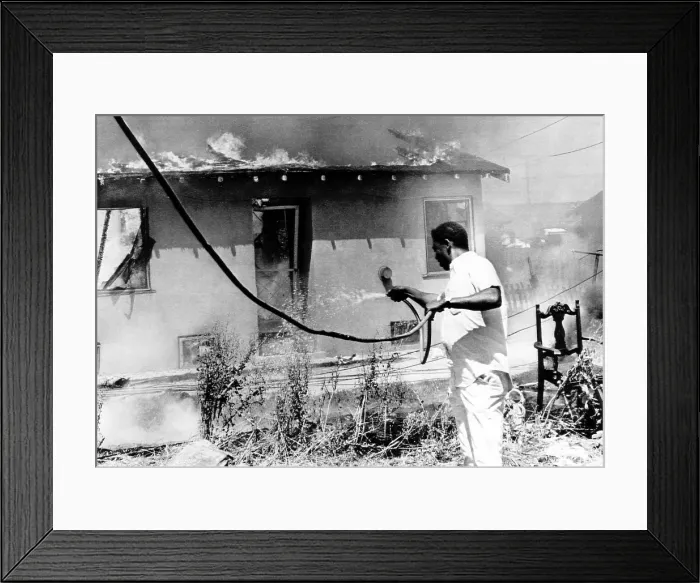 Framed Print : A man attempts to stop the fire destroying his home during the Watts riots. Firemen were unable to enter the area, 1965. Courtesy: CSU Archives / Everett Collection
