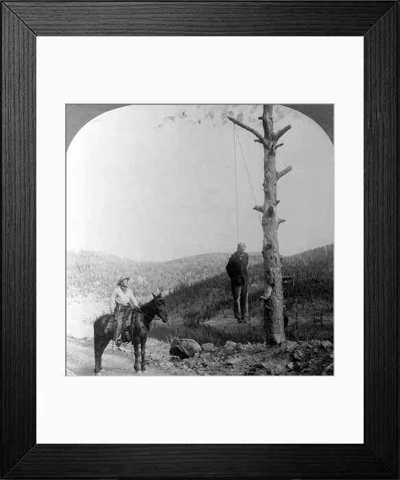 Framed Print : Wild West. Sheriff on horseback looking at stage coach robber hanging by neck from tree, 1911
