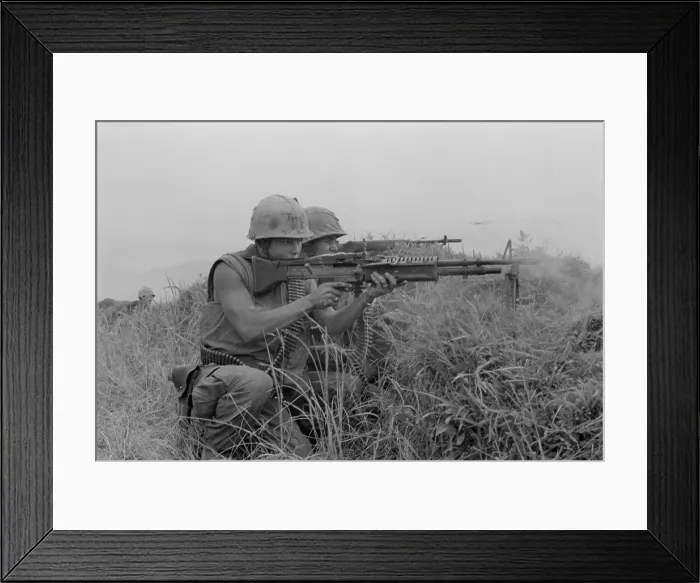 Framed Print : Vietnam War. US Marine machine gunner and rifleman fire at the enemy near the Demilitarized Zone in Vietnam. May 13, 1967