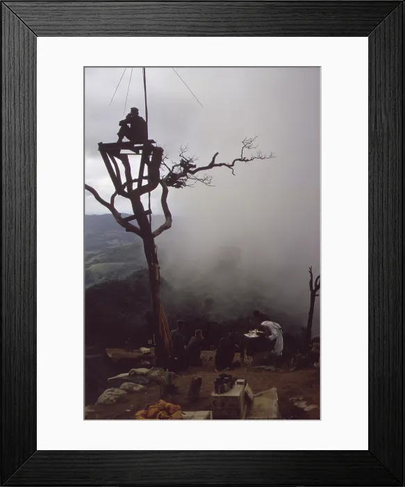 Framed Print : Vietnam War. US Marine stands watch in an observation tower as a Marine chaplain holds mass on Hill 950. Hill 950 was one of four hills surrounding the Khe Sahn Combat base