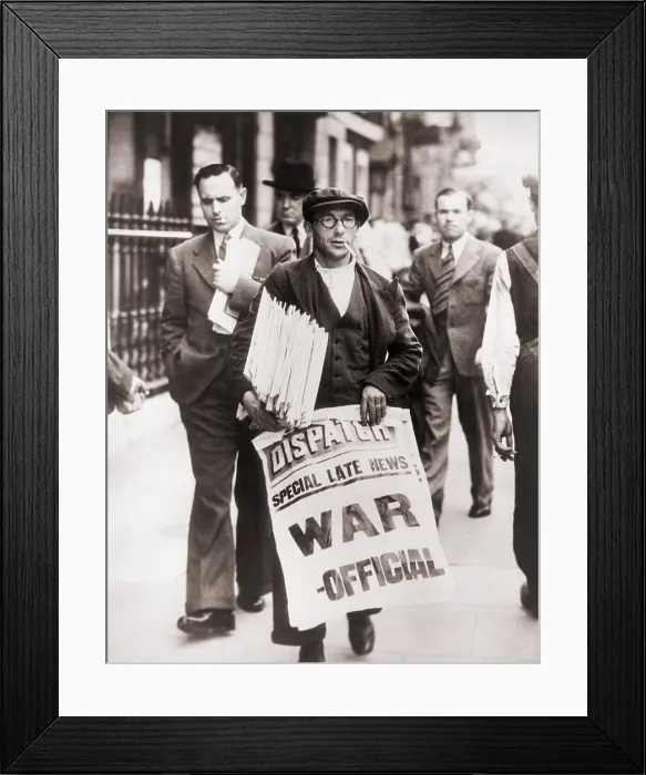 Framed Print : World War II. Announcing state of war with Germany, a British Newspaper man holding stack of newspapers and sign stating Special late news: War - Official, in Whitehall