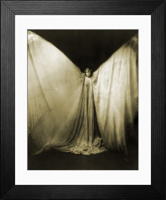 Framed Print : Loie Fuller, (1862-1928), wearing large gown, with arms raised in shape of a butterfly. She developed dances with unique lighting and costumes. 1901