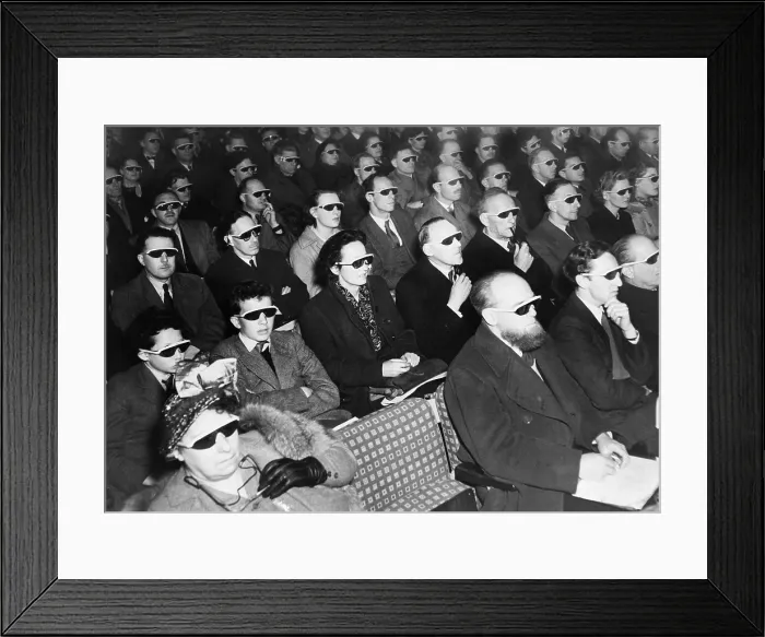 Framed Print : British audience wears smoke-colored glasses to view a 3-D movie in 1954