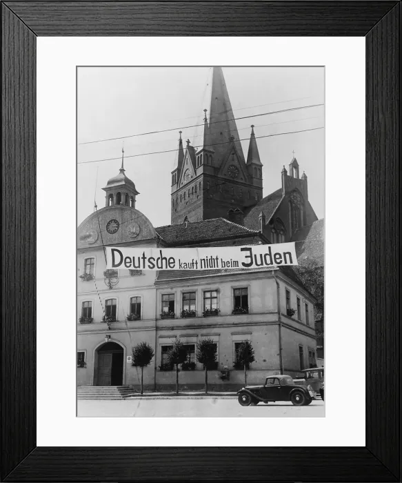 Framed Print : Banner reading Deutsche kauft nich beim Juden (Germans don't buy in Jewish shops) suspended over a street in Greifenberg, Pommerania (now Poland). 1935 Framed Print : Banner reading Deutsche kauft nich beim Juden (Germans don't buy in Jewish shops) suspended over a street in Greifenberg, Pommerania (now Poland). 1935