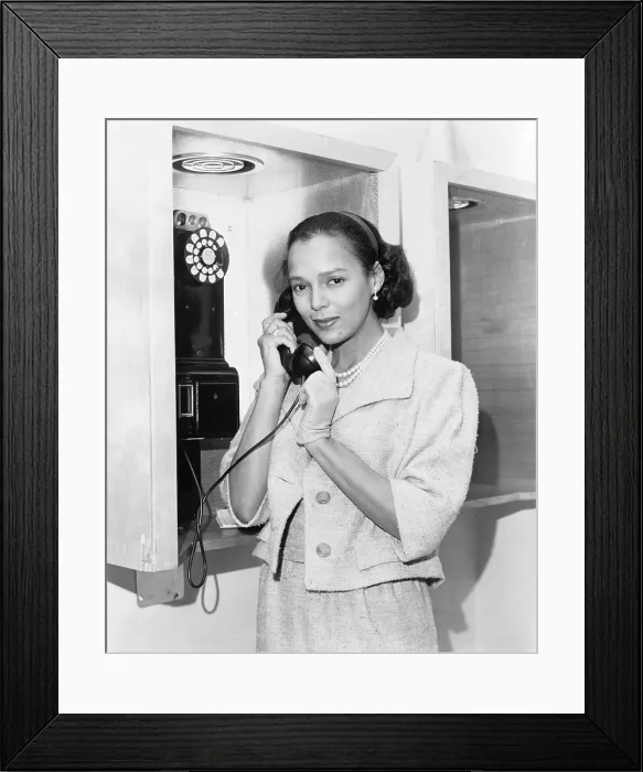 Framed Print : Dorothy Dandridge (1922-1965), half-length portrait, standing, facing left, holding telephone receiver at New York's airport in 1959, the year she starred in PORGY AND BESS