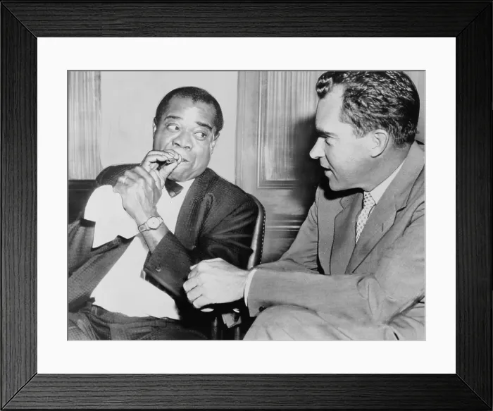 Framed Print : Louis Armstrong (1901-1971) holding horn mouthpiece, demonstrating how to 'make the horn cry' for Vice President Richard Nixon. 1957