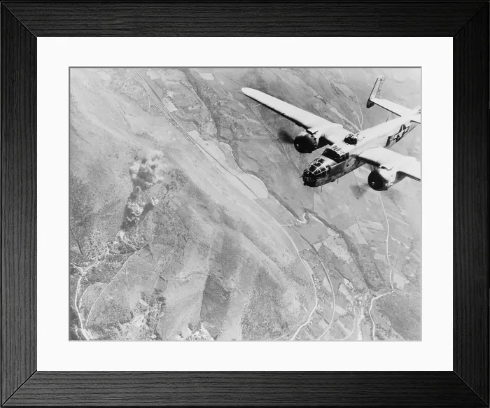 Framed Print : World War II, a Nazi supply dump goes up in smoke. A U.S. B-25 medium bomber roars over Tivoli, Nazi supply center ten miles east of Rome