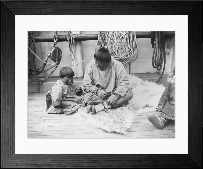 Framed Print : Child learning to smoke a pipe, native American child and man sitting on the deck of a ship