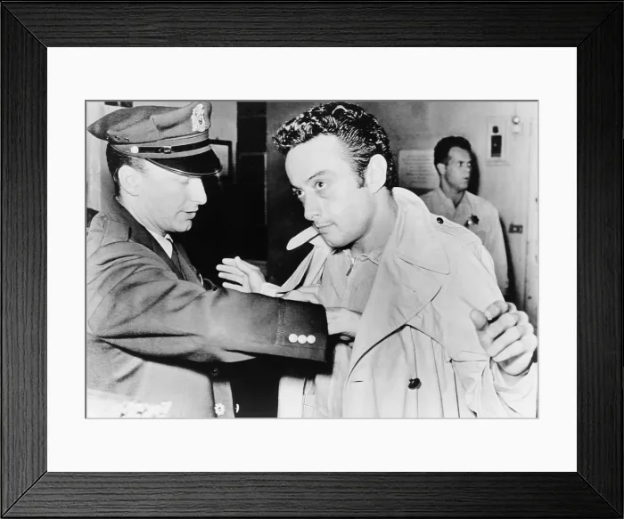 Framed Print : Lenny Bruce (1925-1966), being searched at police station after his October 4, 1961 arrest for using obscene language during his standup act at the Jazz Workshop in San Francisco