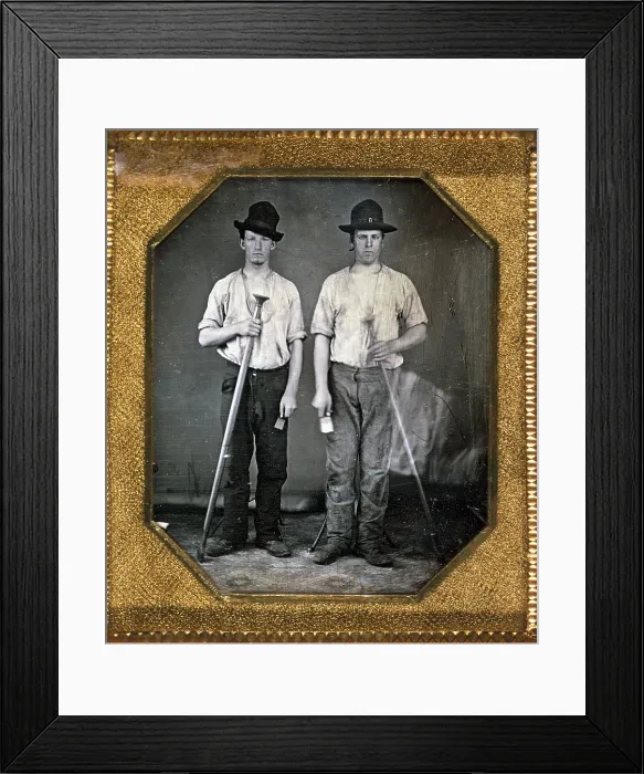 Framed Print : Two men holding floor rammers, foundry tools used for packing sand against molds, sixth-plate daguerreotype, with Eichmeyer variant case, circa 1850