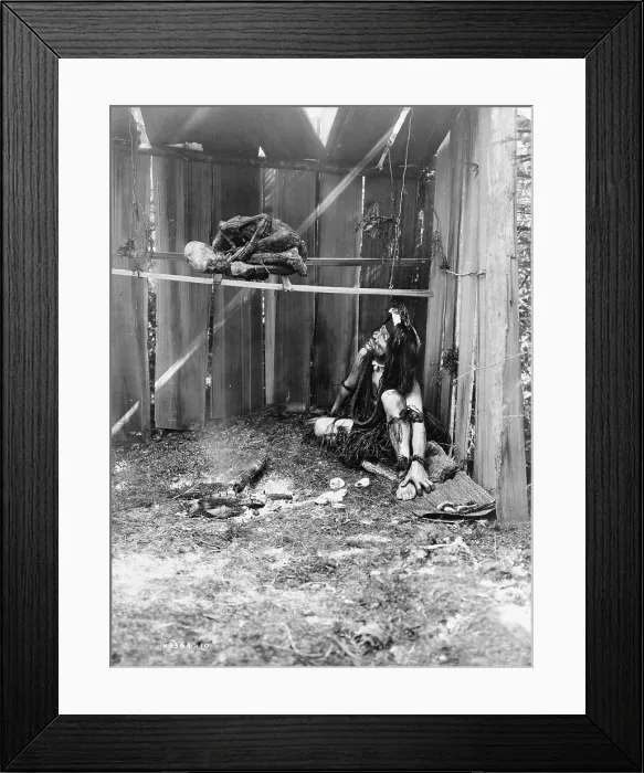 Framed Print : The drying mummy, Kwakiutl man inside board structure, curing mummy over smoke and coals of fire, photograph by Edward S. Curtis, 1910