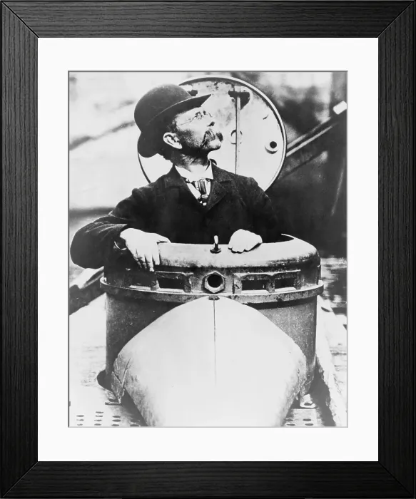 Framed Print : John P. Holland (1841-1914), climbing up hatch of his invention, the USS Holland submarine, the US Navy's first commissioned submarine. Ca. 1900