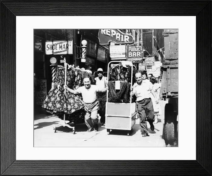 Framed Print : Men pulling racks of clothing on busy sidewalk in Garment District, express the vitality of mid-20th century New York. 1955 Framed Print : Men pulling racks of clothing on busy sidewalk in Garment District, express the vitality of mid-20th century New York. 1955